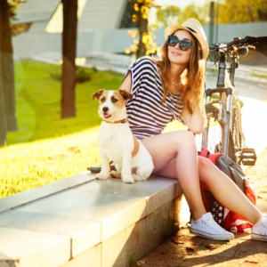 Woman sitting near her bike with her jack russell terrier dog